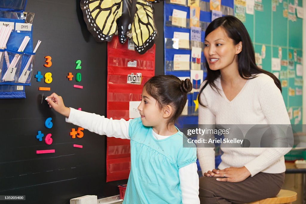 Teacher Watching Student Doing Math At Blackboard High-Res Stock Photo ...