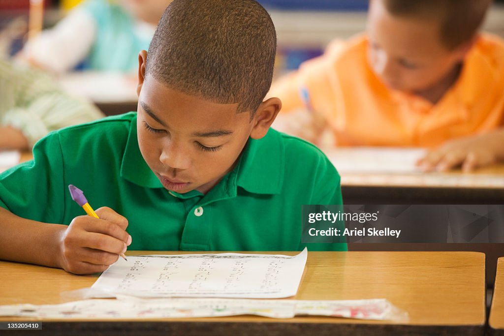 African American student studying at desk in classroom