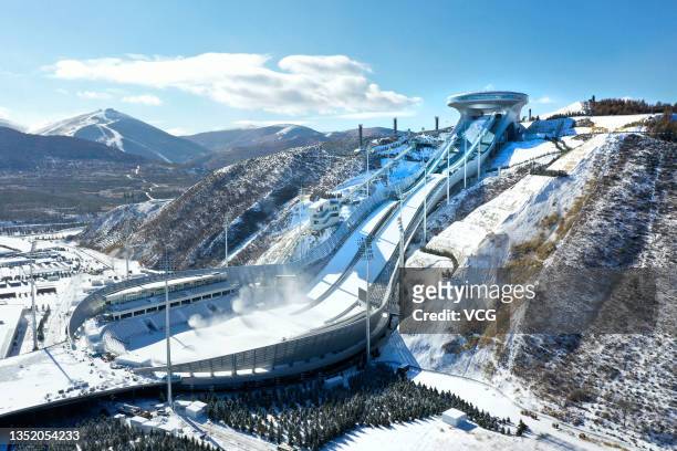 Snowmaking machines operate at the National Ski Jumping Center, nicknamed 'Snow Ruyi', for the 2022 Beijing Winter Olympics in Chongli district on...