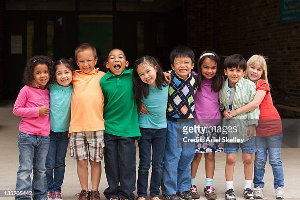 diverso de estudiantes de pie juntos en una fila - group of children fotografías e imágenes de stock