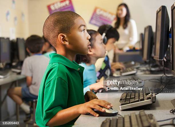 african american boy using computer in classroom - computer training stock pictures, royalty-free photos & images