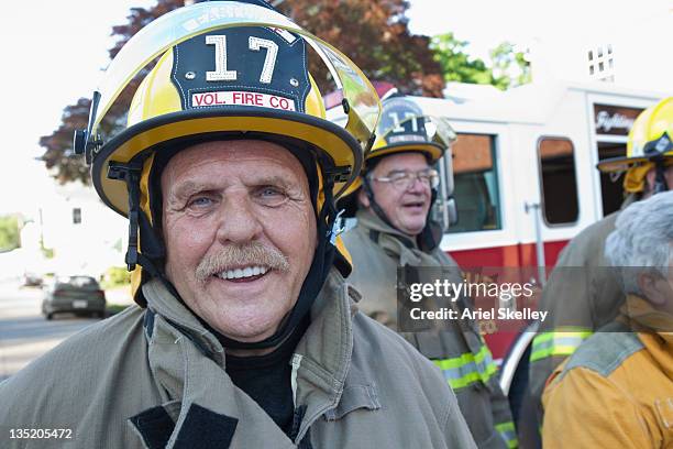 Volunteer firefighters posing outside fire house