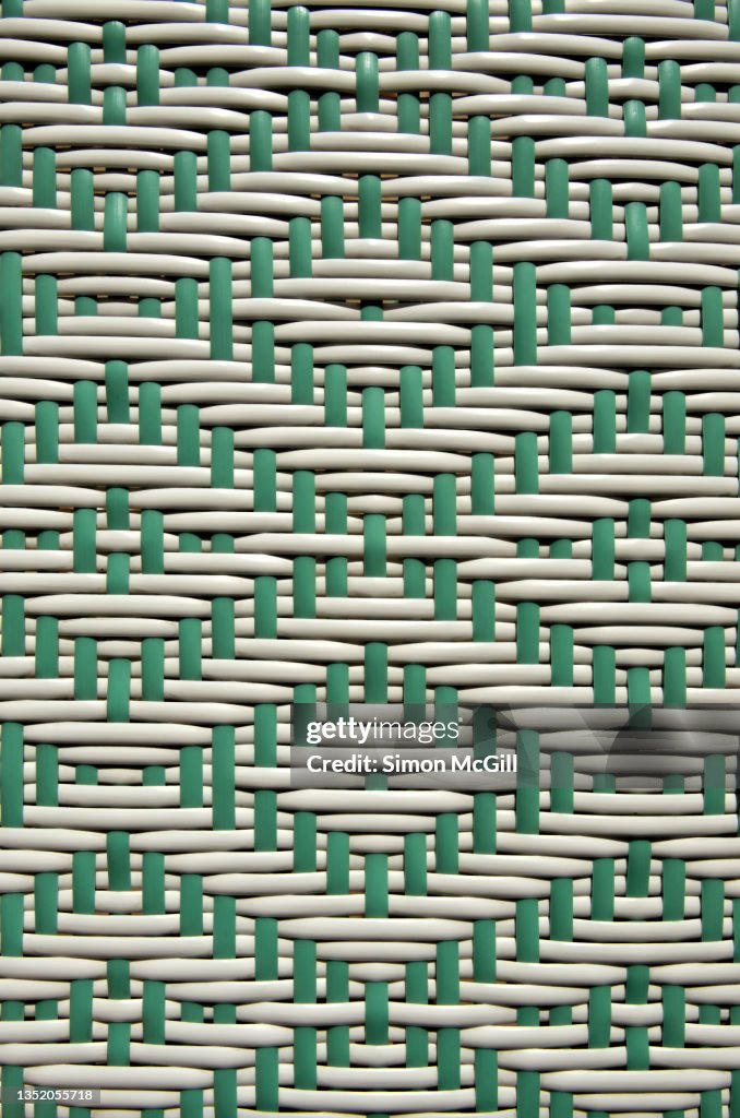 Two-tone green and white diamond weave pattern on plastic rattan/wicker outdoor furniture