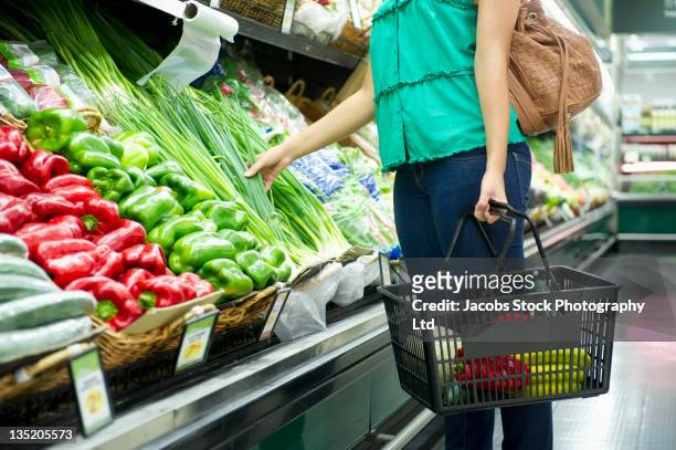 mixed race woman shopping for vegetables - supermarket shopping stock pictures, royalty-free photos & images