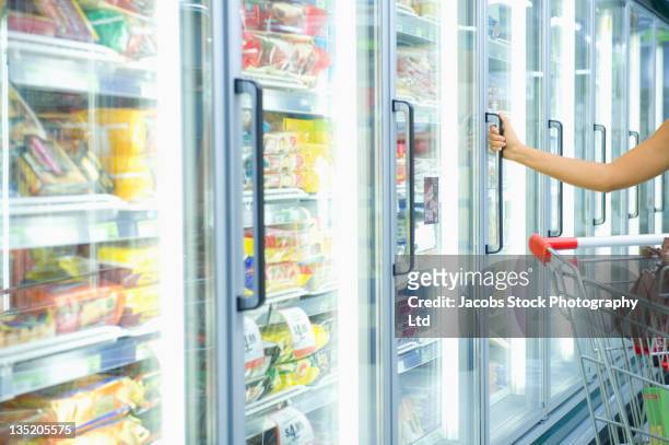 mujer de raza mixta tiendas de alimentos congelados pasillo - congelador fotografías e imágenes de stock