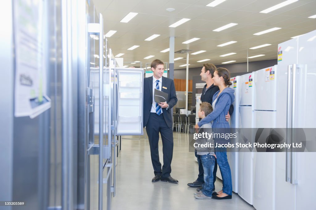 Hispanic family talking to salesman in appliance department