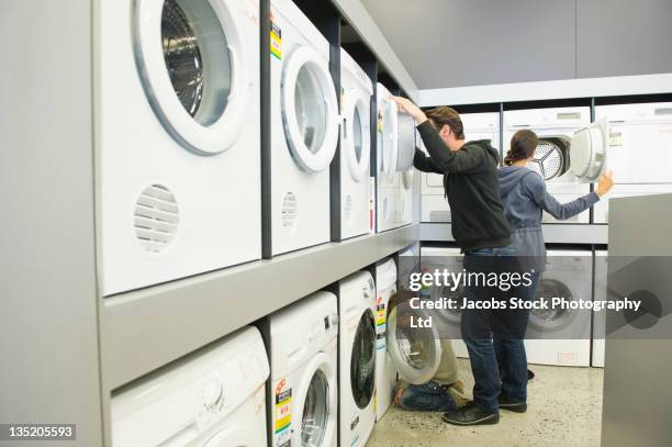 hispanic family looking at washing machines in department store - buying washing machine stock pictures, royalty-free photos & images