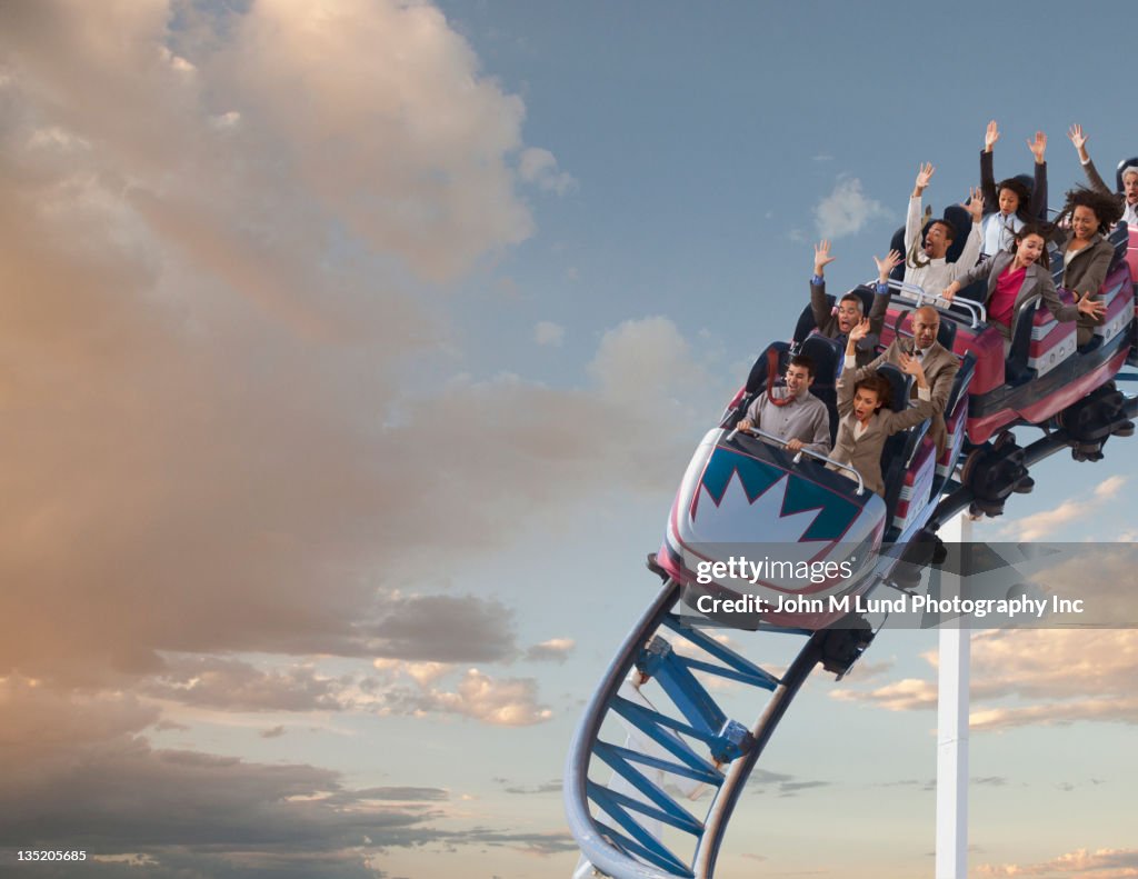 Business people riding roller coaster