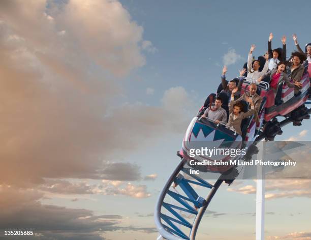 business people riding roller coaster - fairground ride stock pictures, royalty-free photos & images