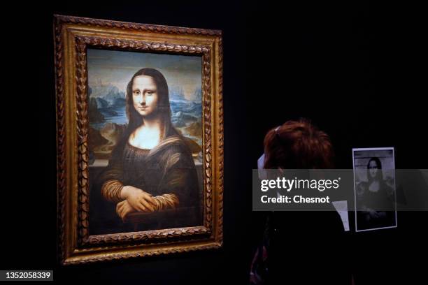 Visitor wearing a protective face mask looks at a Mona Lisa version by Italian artist Leonardo da Vinci at the Artcurial auction house on November...