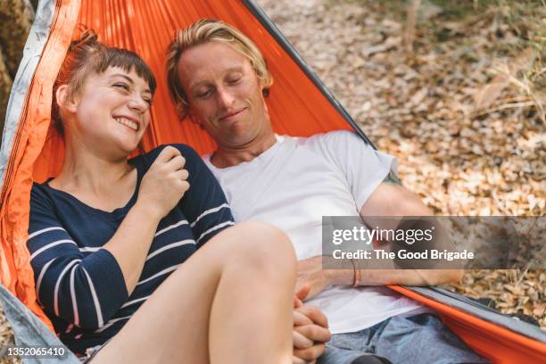 happy girlfriend and boyfriend lying together in hammock - pony play stock-fotos und bilder