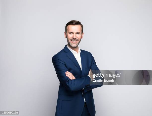 portrait of friendly mature businessman - gray background bildbanksfoton och bilder