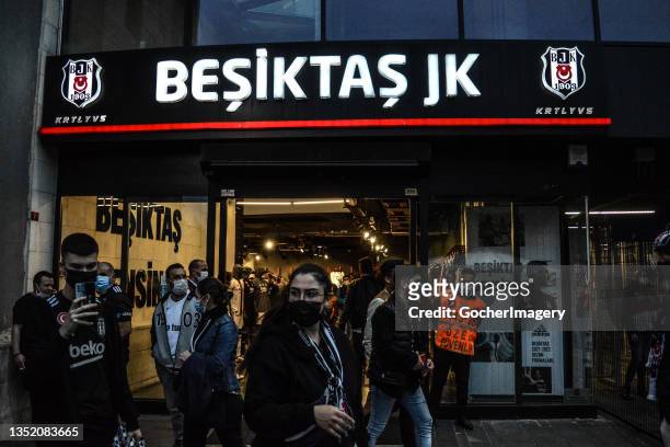 Supporters of Besiktas walk past a fan store outside the stadium ahead of the Turkish Super League match between Besiktas J.K. And Trabzonspor at...