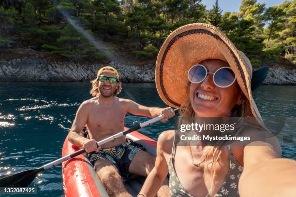 couple take selfie on inflatable canoe in croatia - hvar stockfoto's en -beelden