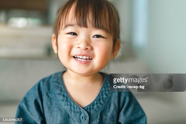 portrait d’une petite fille dans le salon à la maison - sourire photos et images de collection