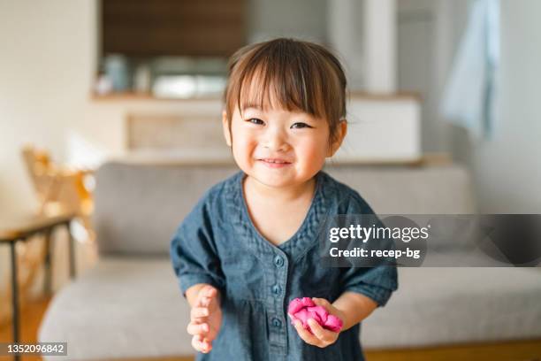 portrait of small girl in living room at home - baby girls stock pictures, royalty-free photos & images