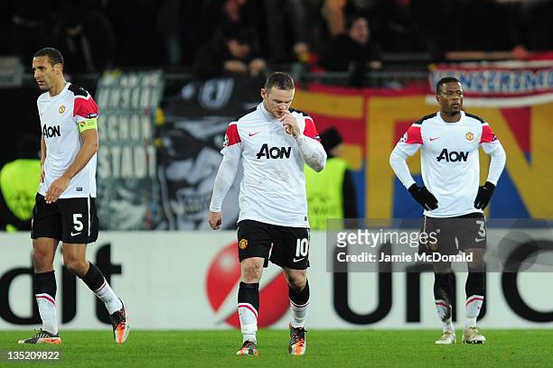 Rio Ferdinand , Wayne Rooney and Patrice Evra of Manchester United walks dejected after Basel scored their second goal during the UEFA Champions...