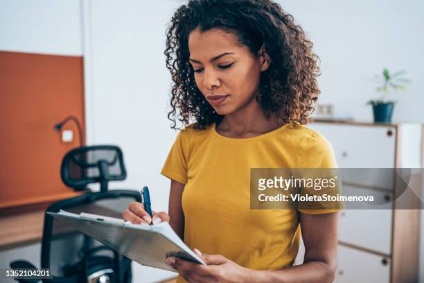 mujer de negocios escribiendo en el portapapeles de la oficina. - clipboard fotografías e imágenes de stock