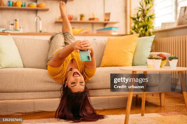 woman checking social media on smart phone at home - upside down bildbanksfoton och bilder