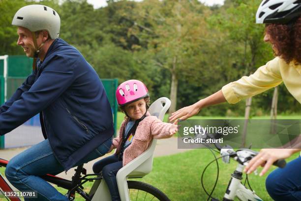 family bike ride to the park - guy in car seat stockfoto's en -beelden