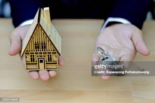 real estate broker agent with house model and keys - estate agency stock-fotos und bilder