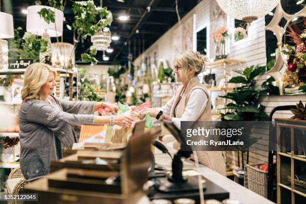 employee rings up customer for her purchase - home decor store stock pictures, royalty-free photos & images