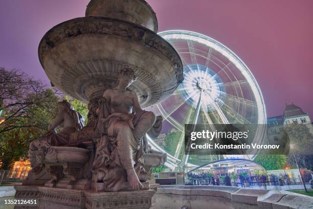 night view view of budapest eye. ferris wheel on long exposure. danube fountain on the foreground. - budapest nightlife stock pictures, royalty-free photos & images