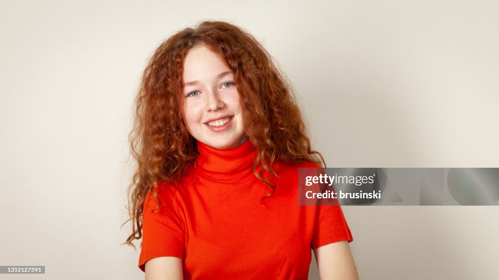 Portrait en studio d’une adolescente de 15 ans aux cheveux roux bouclés