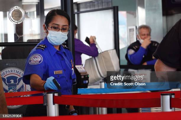 Transportation Security Administration workers screen passengers at O'Hare International Airport on November 08, 2021 in Chicago, Illinois. Monday is...