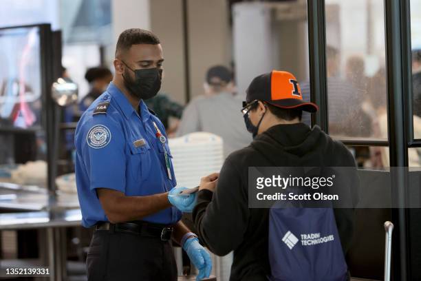 Transportation Security Administration workers screen passengers at O'Hare International Airport on November 08, 2021 in Chicago, Illinois. Monday is...