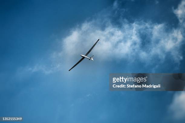 glider flying in the clouds - glider photos et images de collection