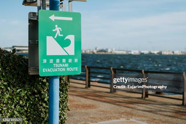 close up of tsunami evacuation route sign - evacuation stock pictures, royalty-free photos & images