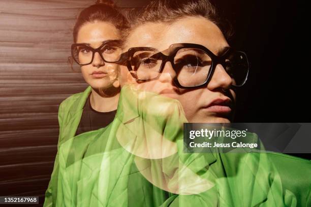 caucasian girl, with fashion glasses, looking at the camera, with a serious expression. with a wall of the street background. triple exposure effect. girls, psychology, companies and business women concept. - multiple exposure stock-fotos und bilder
