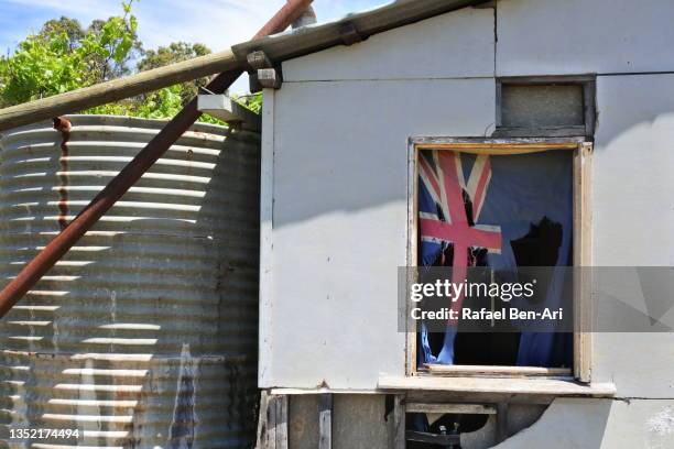 worn australian flag on old farm house window - australia capital cities stock pictures, royalty-free photos & images