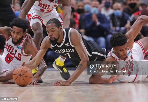 Kevin Durant of the Brooklyn Nets dives for a loose ball between Derrick Jones Jr. #5 and Tony Bradley of the Chicago Bulls at the United Center on...