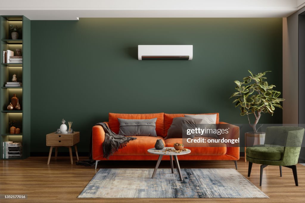 Interior moderno da sala com ar condicionado, sofá laranja e poltrona verde
