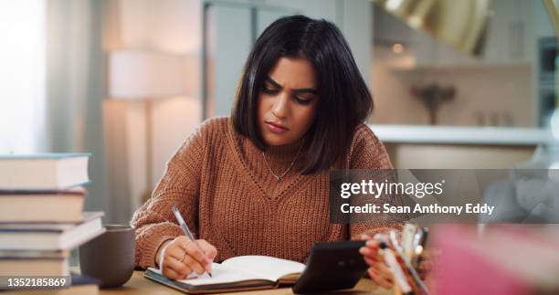 shot of a young woman looking confused while studying at home - mistaken identity stock pictures, royalty-free photos & images