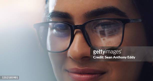 nahaufnahme einer jungen frau mit brille bei der arbeit zu hause - frau gesicht brille stock-fotos und bilder