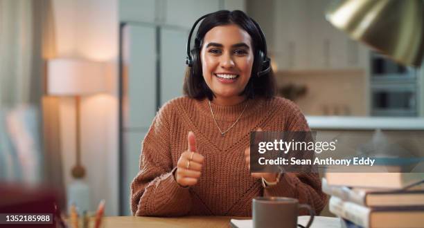 portrait of a young woman showing thumbs up while studying at home - representing stock pictures, royalty-free photos & images