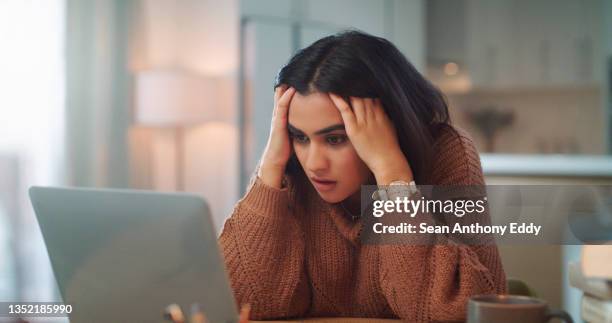 shot of a young woman looking stressed out while using a laptop to study at home - mistaken identity stock pictures, royalty-free photos & images