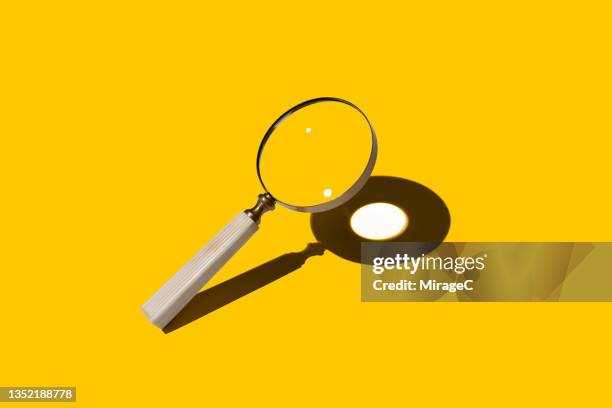 magnifying glass focusing sunlight into a spot - convex stock pictures, royalty-free photos & images