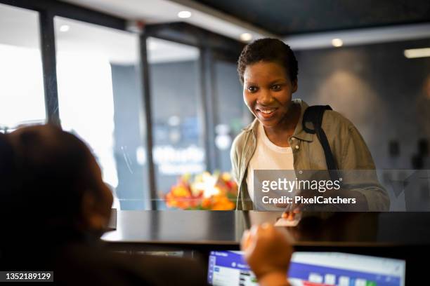 young woman collecting hotel card key at reception - nyckelkort bildbanksfoton och bilder