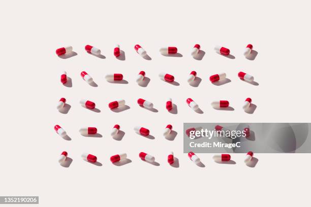 neatly arranged red capsules - red capsule stock pictures, royalty-free photos & images