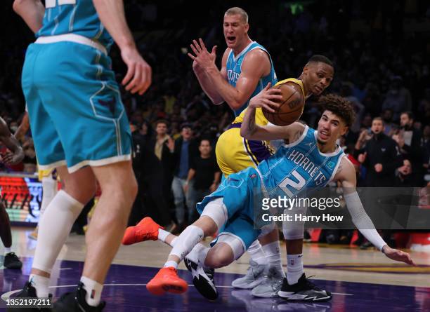 LaMelo Ball of the Charlotte Hornets grabs a rebound from Russell Westbrook of the Los Angeles Lakers as Mason Plumlee calls timeout during a 126-123...