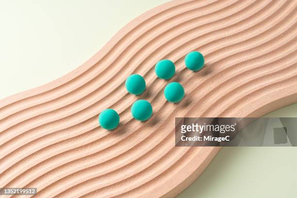 green spheres moving up on wavy wood - organised group stock pictures, royalty-free photos & images