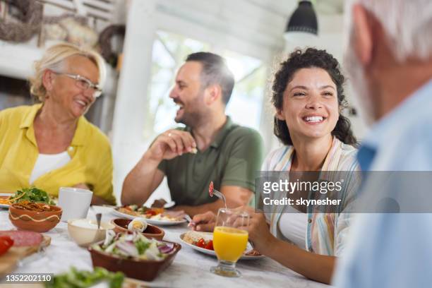 happy adult offspring talking to their parents during a meal at dining table. - father in law stock pictures, royalty-free photos & images