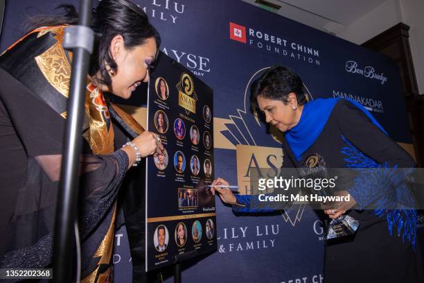 Maki Hsieh holds a poster board as Indra Nooyi signs it during the Asian Hall of Fame induction reception at Ben Bridge Jeweleron November 08, 2021...
