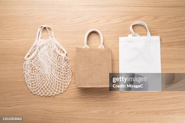 plastic free reusable shopping bag options on wood table - hessian stock pictures, royalty-free photos & images