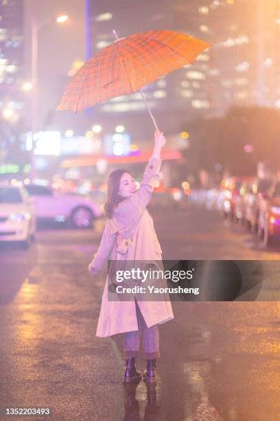 one asia woman walking on the shanghai city night street with a red umbrella - rainy season stock pictures, royalty-free photos & images