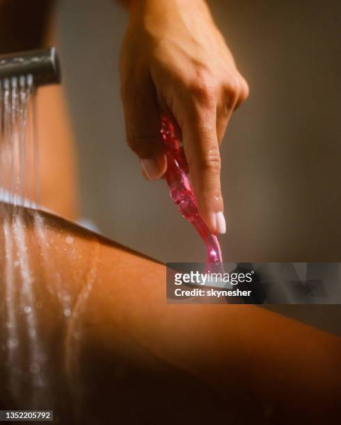 woman shaving her leg in the bathroom. - shaved stockfoto's en -beelden